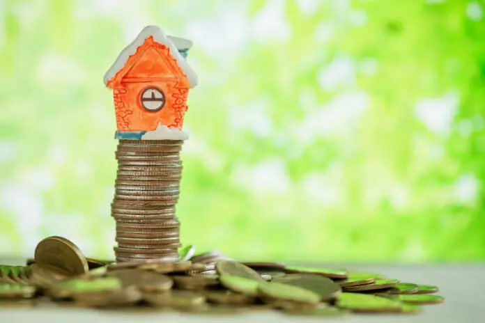 mini house stacked on coins