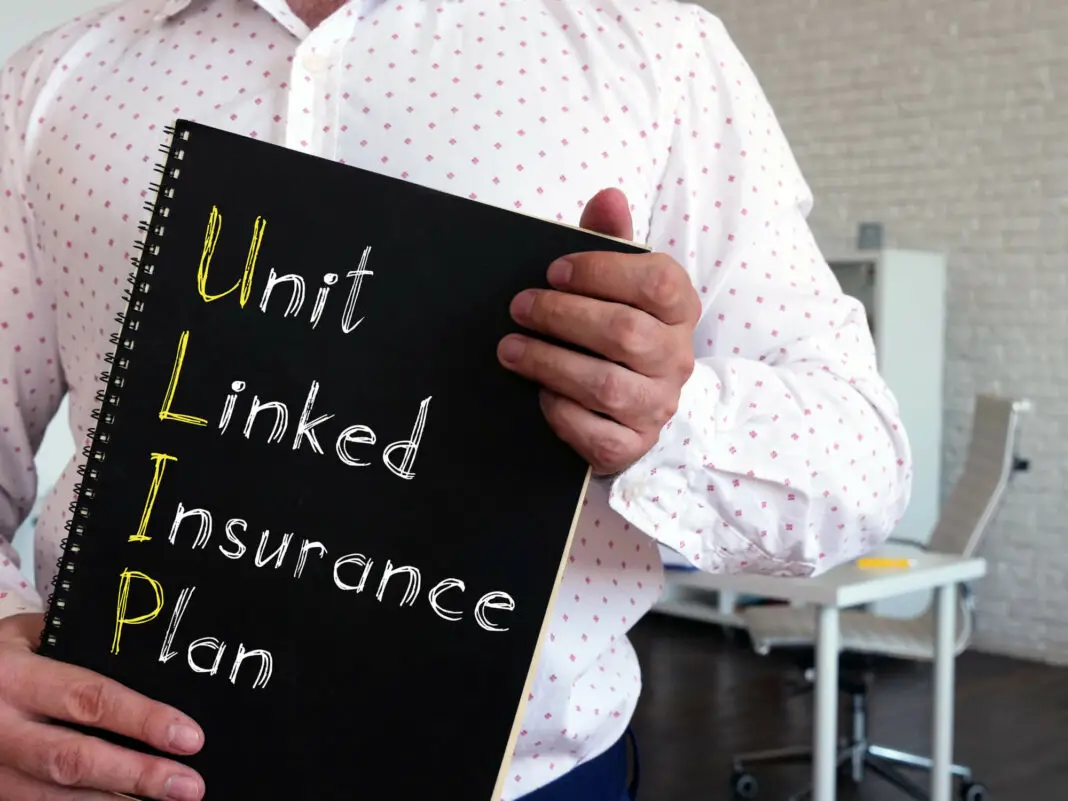 Man holding a notebook that says Unit Linked Insurance Plan